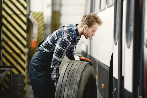 worker-with-wheel-wheel-replacement-man-uniform_Tires Easy