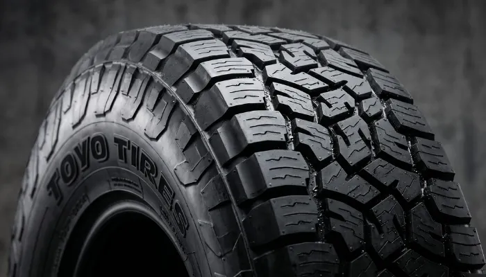 Close-up of Toyo Open Country A/T III tire tread pattern highlighting wet traction grooves.