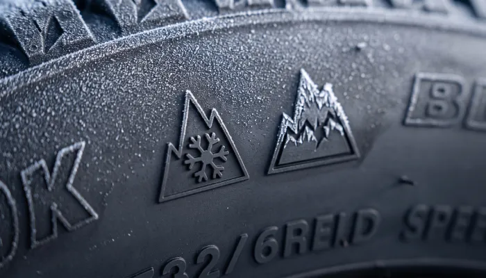 Three-peak mountain snowflake and Ice Grip symbols on the sidewall of a winter tire.